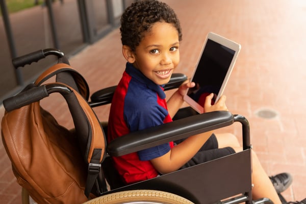 disabled-schoolboy-with-digital-tablet-looking-at-JH8U6F2